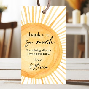 Könnte beinhalten: Ein Dankeschön-Etikett mit einer Aquarell-Illustration einer Sonne mit Strahlen. Der Text lautet "Vielen Dank" und "Dafür, dass du all deine Liebe auf unser Baby strahlst. Liebe, Olivia."