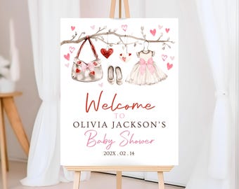 May include: Welcome to Olivia Jackson's Baby Shower sign with a pink and white dress, a purse, and red hearts hanging from a branch. The date is 202X.02.14.