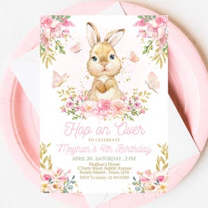 Peut inclure: Une invitation rose et or avec une illustration mignonne de lapin. L'invitation indique "Hop on Over to Celebrate Meghan's 4th Birthday".