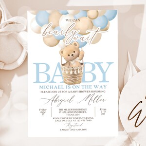 May include: A baby shower invitation with a blue and beige color scheme. The invitation features a teddy bear in a hot air balloon made of balloons. The text on the invitation reads "We can barely wait" and "Baby Michael is on the way".