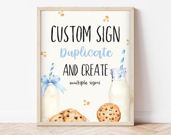Op de afbeelding: Een printbaar bord met de tekst "CUSTOM SIGN Duplicate and CREATE multiple signs" in zwarte tekst op een witte achtergrond. Het bord is ingelijst in een licht houten frame. Er zijn twee glazen flessen melk met blauw-wit gestreepte rietjes en blauwe linten. Er liggen ook drie chocoladekoekjes op een wit oppervlak.