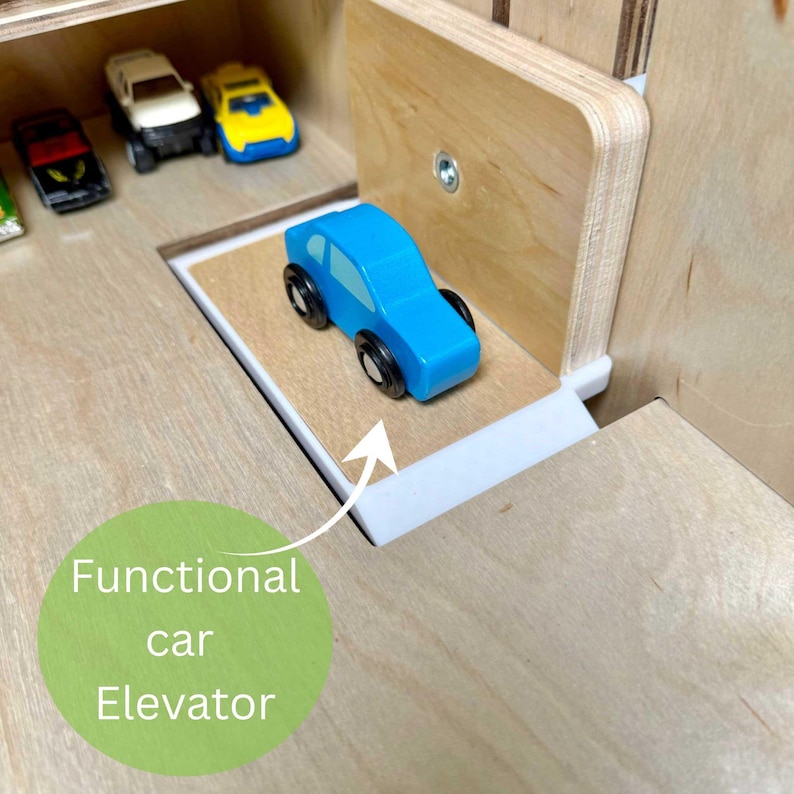 May include: A wooden toy car elevator with a blue toy car on the platform. The elevator is part of a larger wooden toy set, with other toy cars visible in the background. The text "Functional car Elevator" is in a green circle.