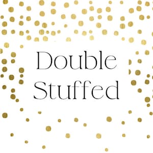 May include: White background with gold confetti and the words "Double Stuffed" in a black, elegant font. The design is simple and clean, with a playful, celebratory feel.