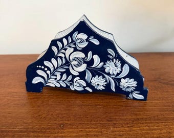 Servilletero de madera pintado a mano, de estilo folclórico, con estampado floral azul.