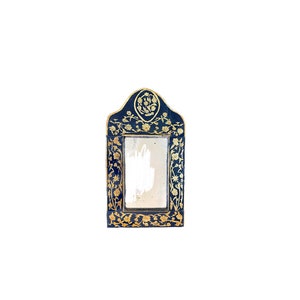 May include: A small, black framed mirror with gold floral details. The mirror has a simple, rectangular shape and is perfect for a small space.