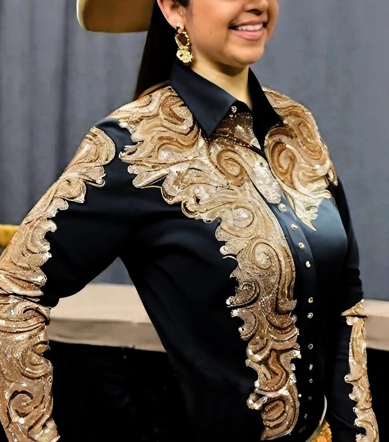 May include: Black long-sleeve shirt with gold embroidery. The embroidery features a swirling, ornate design.