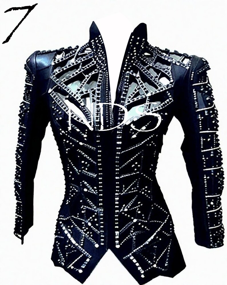 May include: A black leather jacket with a geometric design and rhinestones. The jacket has a stand-up collar and long sleeves.