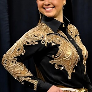May include: A black long-sleeved shirt with gold embroidery. The embroidery features a paisley design.