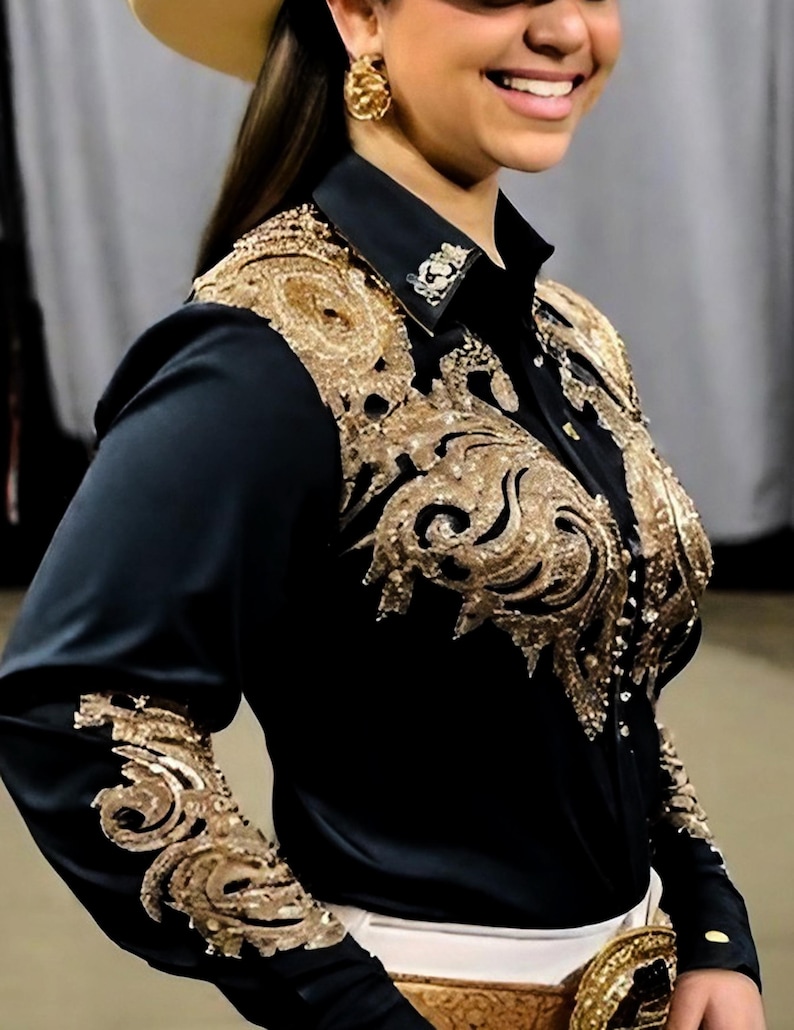 May include: A black long-sleeved shirt with gold embroidery on the front and sleeves. The shirt has a collar and button closure.