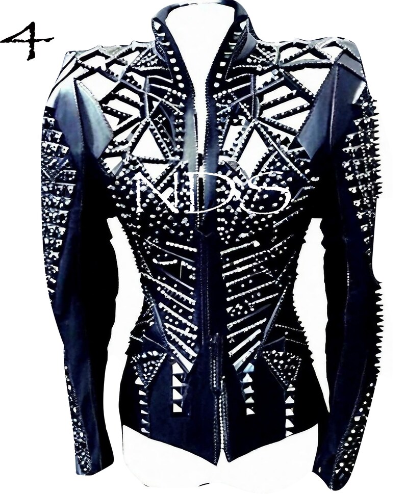May include: Black leather jacket with a geometric design and silver studs. The jacket has a zipper closure and long sleeves.