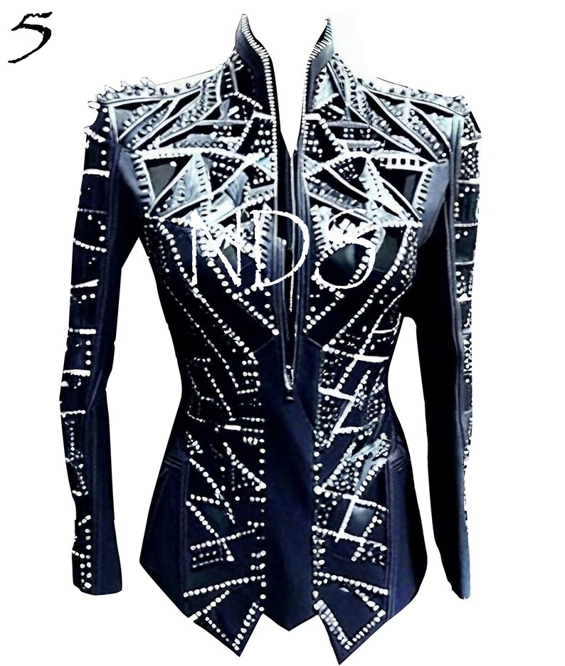 May include: Black leather jacket with a geometric design and silver embellishments. The jacket has a zipper closure and a stand-up collar.
