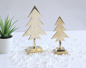May include: Two gold metal Christmas tree ornaments on a white surface. The larger tree is about 25 cm tall and the smaller tree is about 15 cm tall.