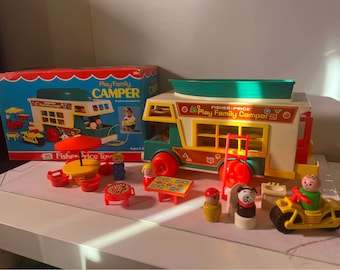 May include: Vintage Fisher-Price Play Family Camper toy set. The set includes a camper van, miniature figures, and accessories like a table, chairs, and a grill. The camper is white, green, and orange, with red wheels. The box is also included.