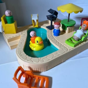 Peut inclure: Un ensemble de jeu vintage Fisher-Price représentant une scène de piscine. L'ensemble comprend une piscine, des figurines, un canard jaune, un barbecue, une table avec un parasol jaune et une chaise longue. Les figurines sont dans diverses poses.