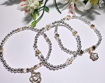 Set di bracciali scintillanti con ciondoli a forma di fiore in argento e oro. Set regalo di gioielli con perline in stile boho per amanti della natura. Per mamma, sorella, moglie