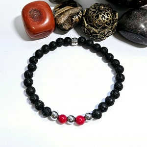May include: Black lava rock beaded bracelet with three red beads and silver spacer beads.