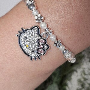 Pulsera elástica apilable de Hello Kitty con cuentas brillantes en plata y rosa, con dije. Regalo de joyería con el adorable gato de Sanrio de Hello Kitty y sus amigos.