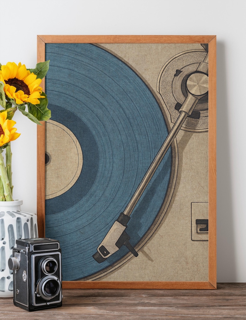 May include: A framed print of a vintage record player with a blue vinyl record. The artwork has a retro aesthetic, with a wooden frame and a neutral background. A vase of sunflowers and a vintage camera are in the foreground.