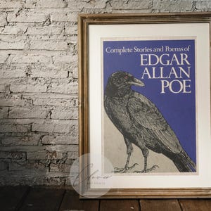 May include: A framed print of "Complete Stories and Poems of Edgar Allan Poe" with a raven illustration. The artwork has a blue background and is in a wooden frame. The image is set against a brick wall.