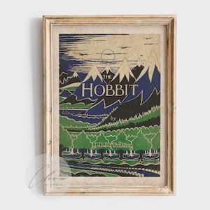 Puede incluir: Impresión vintage enmarcada de "El Hobbit" de J.R.R. Tolkien. La obra de arte presenta un paisaje con montañas, árboles y el título en letras en negrita. La paleta de colores incluye tonos verdes, azules y beige, con un aspecto envejecido y desgastado.