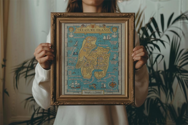 May include: A person holding a framed map of Treasure Island. The map is in a gold frame and has a blue background with a yellow island in the center. The map is surrounded by a white border.