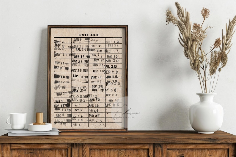 May include: A framed print with a vintage style calendar design. The calendar is printed on a beige background with black text. The text reads "DATE DUE" and lists dates throughout the year.