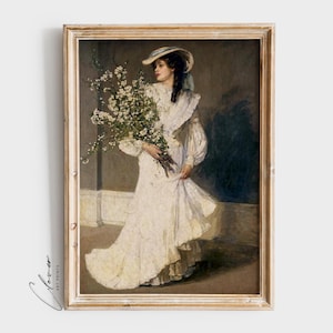 Op de afbeelding: Een schilderij van een vrouw in een witte jurk die een boeket witte bloemen vasthoudt. Ze staat in een kamer met een donkere achtergrond. Het schilderij is ingelijst in een licht houten lijst.