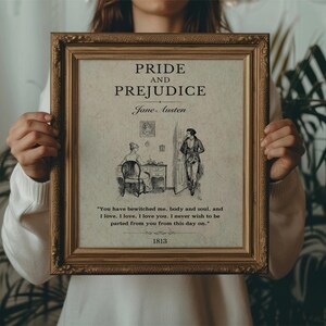 May include: A framed print of the book cover for Pride and Prejudice by Jane Austen. The cover features a black and white illustration of two people in a room. The quote "You have bewitched me, body and soul, and I love, I love, I love you. I never wish to be parted from you from this day on." is printed below the illustration. The year 1813 is printed at the bottom of the print.