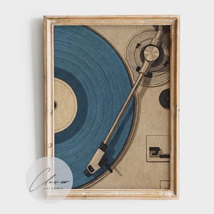 May include: A framed art print featuring a vintage turntable with a blue vinyl record. The artwork has a retro aesthetic, with a beige background and a wooden frame. The turntable's details are finely illustrated.