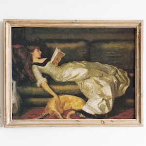 May include: A framed painting of a woman in a white dress lying on a couch with a book in her hand. A brown and white dog is lying at her feet.