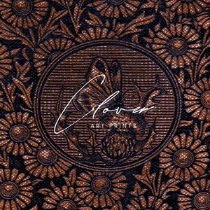 May include: A close-up of a brown and black floral pattern with a circular design in the center. The center design features a stylized flower with the text "Clover Art Prints".
