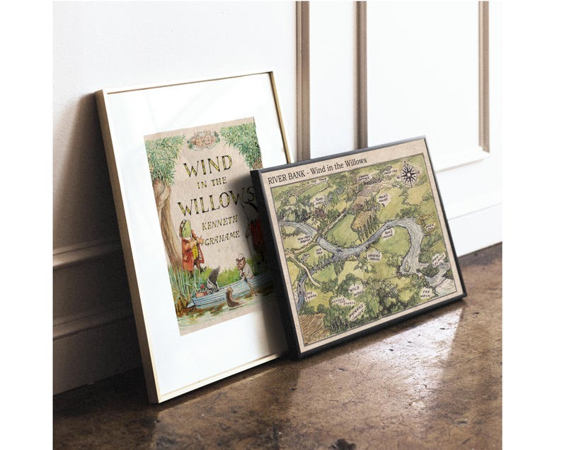 May include: Two framed prints leaning against a wall. One features the book cover of "Wind in the Willows" by Kenneth Grahame, with illustrations. The other is a map titled "River Bank - Wind in the Willows", with a compass rose.