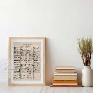 May include: A framed print of a vintage date due list with handwritten dates in black ink. The print is in a light wood frame and is hanging on a white wall.