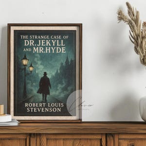 May include: A framed print of "The Strange Case of Dr. Jekyll and Mr. Hyde" by Robert Louis Stevenson. The artwork depicts a silhouetted figure walking on a cobbled path, with street lamps and a dark cityscape in the background. The print is displayed on a wooden cabinet.