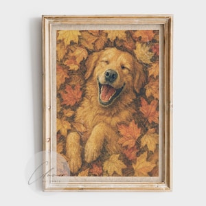 May include: A framed print of a Golden Retriever dog lying in a pile of autumn leaves. The dog is smiling with its mouth open. The leaves are shades of yellow, orange, and red. The frame is a light brown color.