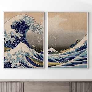 May include: A pair of framed prints depicting a traditional Japanese woodblock print of a large wave crashing over a boat. The wave is blue and white, and the background is a light brown.