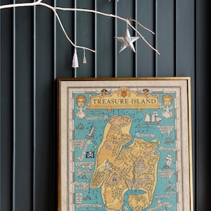 May include: A vintage-style map of Treasure Island, featuring a detailed illustration of the island with various landmarks and locations. The map is printed on a cream-colored paper with a gold frame.