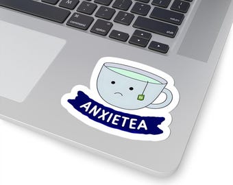 May include: A white teacup with a sad face and a tea bag inside. The teacup is on a blue banner with the text "ANXIETEA" in white.