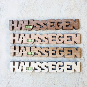 May include: Four wooden signs with the word "Haus Segen" spelled out in large letters. Each sign has a small level embedded in the wood.