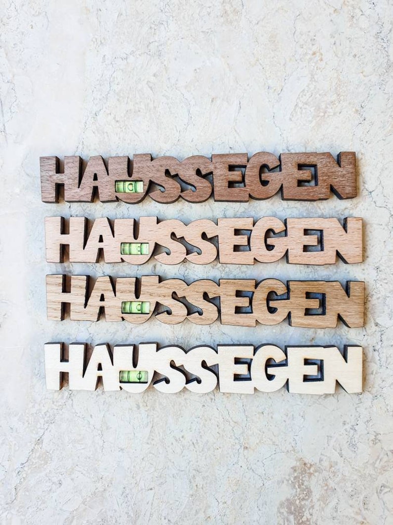May include: Four wooden signs with the word "Haus Segen" spelled out in large letters. Each sign has a small level embedded in the wood.