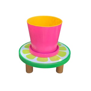 May include: A pink and yellow planter pot with a green and yellow lemon-shaped base and three wooden legs.