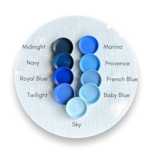 May include: A color chart of blue paint samples, arranged from darkest to lightest. The colors are labeled: Midnight, Navy, Royal Blue, Twilight, Sky, Marina, Provence, French Blue, and Baby Blue.