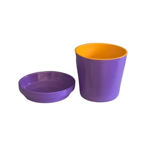 May include: Purple plastic flower pot with a yellow rim and a matching purple saucer.