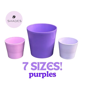May include: Three purple plastic plant pots in different sizes. The largest pot is a deep purple, the medium pot is a lighter purple, and the smallest pot is a pale lavender. The text "9 SHADES" and "7 SIZES! purples" is visible below the pots.