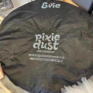 Peut inclure: Sac de danse noir avec les mots "Pixie Dust Dancewear" et "Evie" imprimés dessus. Le sac a une fermeture à cordon et est fait d'un matériau durable.