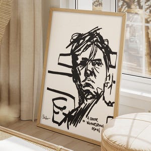 Puede incluir: Una impresión artística enmarcada con un boceto en blanco y negro de un rostro. La obra de arte está en un marco de madera y se apoya contra una pared. El texto "A Doctor in Weatherspoons" es visible en la esquina inferior derecha.