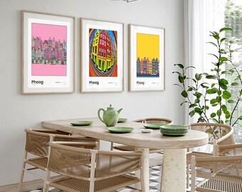 May include: Three framed prints of colorful cityscapes with the word "Phoog" printed below each image. The prints are hanging on a white wall above a wooden dining table with four chairs.
