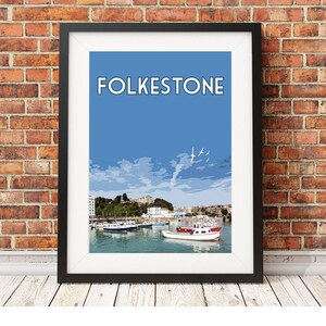 May include: A colourful illustration of the harbour in Folkestone, England. The image features a blue sky with white clouds, a red and white boat in the foreground, and a cityscape in the background. The text "FOLKESTONE" is printed in white letters on a blue background.