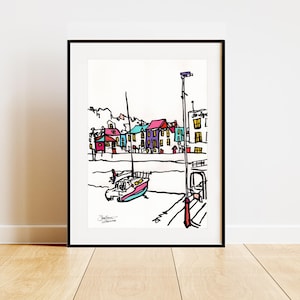 Puede incluir: Una impresión artística enmarcada que presenta un dibujo lineal colorido de una escena portuaria. La obra de arte representa edificios con tejados rojos, azules y morados, un velero y un muelle. La impresión está en un marco negro y se exhibe sobre un suelo de madera.