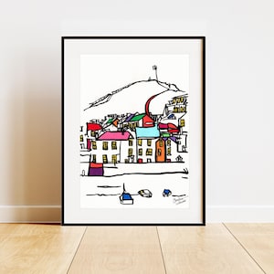 Puede incluir: Una impresión artística enmarcada que presenta una colorida ilustración de un pueblo costero. La obra de arte representa edificios con vibrantes tejados rojos, azules, verdes y naranjas, sobre un fondo blanco. Un contorno negro define la escena, con una colina y barcos.